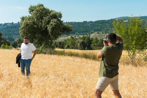 istock Photographer doing a photo shoot in a field to a model 1161585435