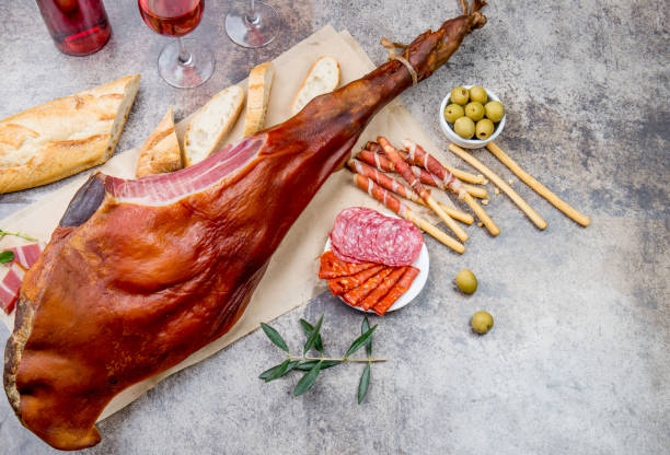 istock Whole leg HAM JAMON SERRANO and rose wine on gray background. Top view. Flat lay 1161586802