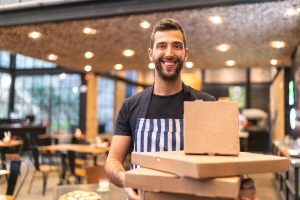 istock Delivery man holding pizza boxes of different sizes 1161587025