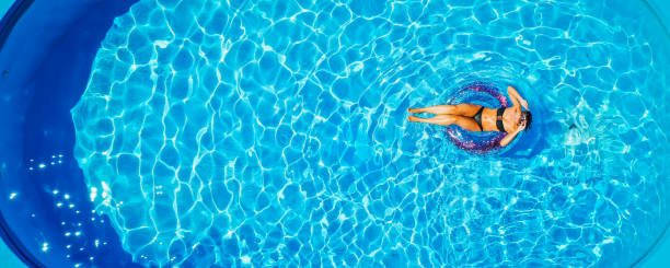 kobieta w cieszy się wodą w pierścieniu pływackim - moisturizing cream audio zdjęcia i obrazy z banku zdjęć
