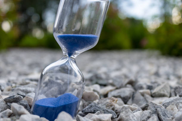 clessidra con bella sabbia blu giace su piccole pietre - close up of a broken bottle, street foto e immagini stock
