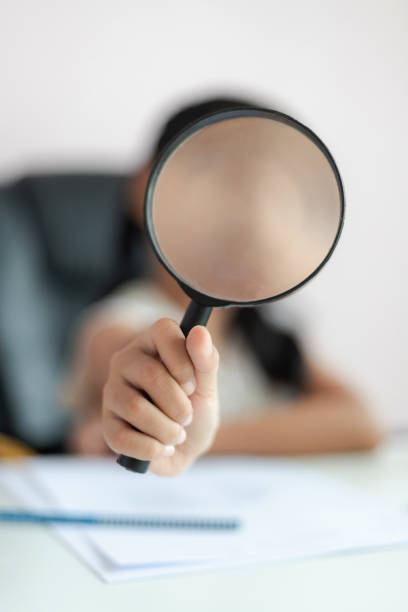 istock Little Asian girl using magnifier doing homework for education concept select focus shallow depth of field 1161592069