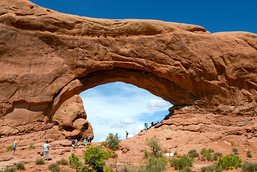 Small window arch with cliffs behind. Arches National Park, Utah.