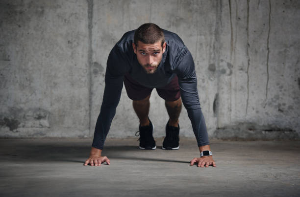 Portrait of a handsome young sportsman doing push ups while exercising inside a parking lot