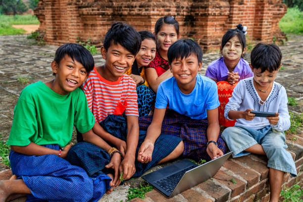 Burmese children using laptop in temple, Old Bagan, Myanmar Burmese children with thanaka using laptop in the ancient temple of Bagan, Myanmar (Burma) bagan archaeological zone stock pictures, royalty-free photos & images