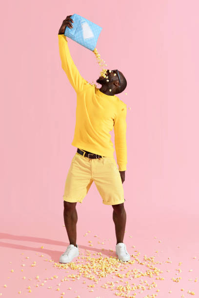 istock Happy black man eating pop corn from pack, having fun portrait 1161598757