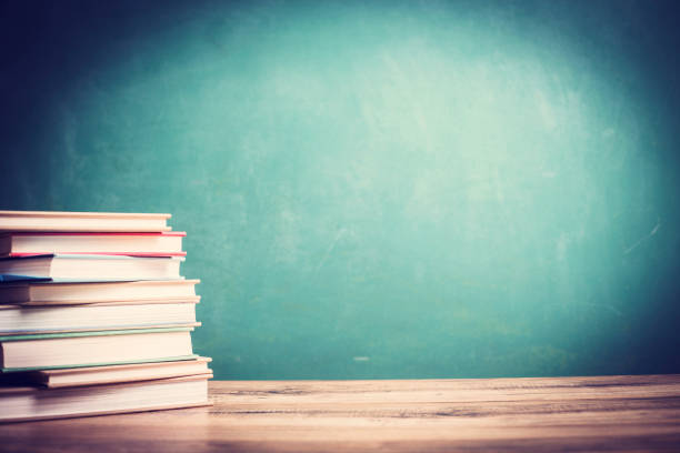 istock Textbooks on wooden school desk with chalkboard. 1161598898