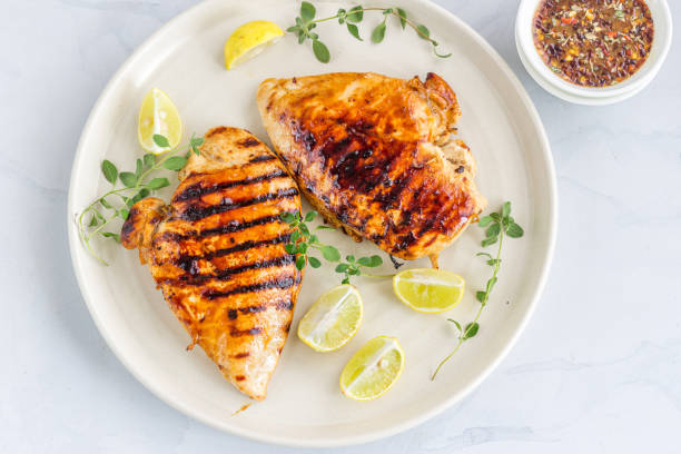 Grilled Chicken Breast Directly Above Photo Grilled Chicken Breast on a White Plate with Lemon and Fresh Oregano. grilled chicken breast stock pictures, royalty-free photos & images