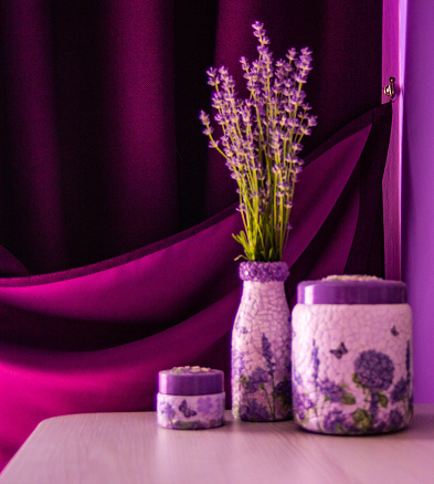 Lavender in the vase  on the table. Purple curtain and violet wall background.