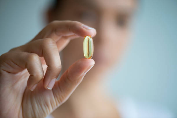 istock Woman Showing A Vitamin Capsule 1161602403