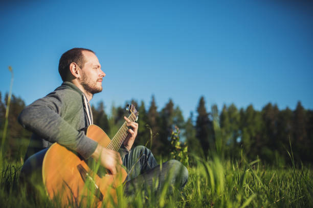 istock Man playing acoustic guitar outdoors 1161602743