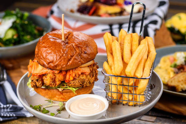 Chicken Burger A fried chicken burger on a plate with chips pub food stock pictures, royalty-free photos & images