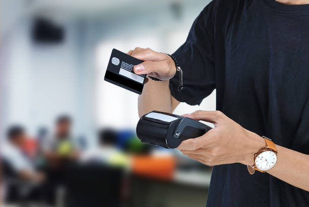 istock Young asian student holding an Electronic Data Capture (EDC) machine and ready to swipe credit card or debit card for pay over beautiful blur background 1161604431