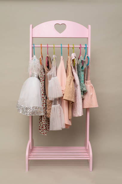 istock Little girls clothes on hanger rack vertical background 1161604947