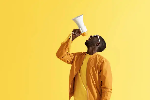 Photo of Advertising. Man screaming announcement in megaphone portrait