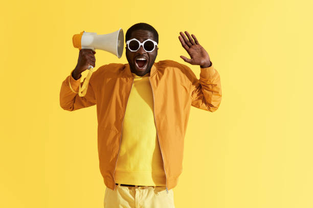 istock Happy black man with megaphone having fun, studio portrait 1161606102