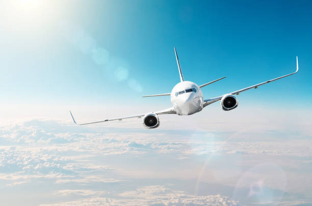 istock Airplane performs a high turn in the sky above the sun shines reflecting glare light. 1161608424