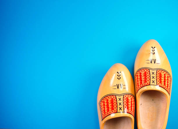istock Traditional dutch wooden clogs isolated on blue background with copy space for your own text just for holiday or postcard etc 1161609180