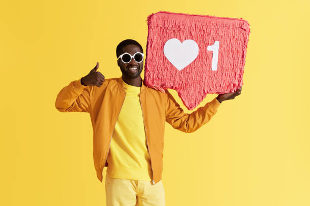 istock Smiling black man with like icon pinata showing thumbs up 1161609392