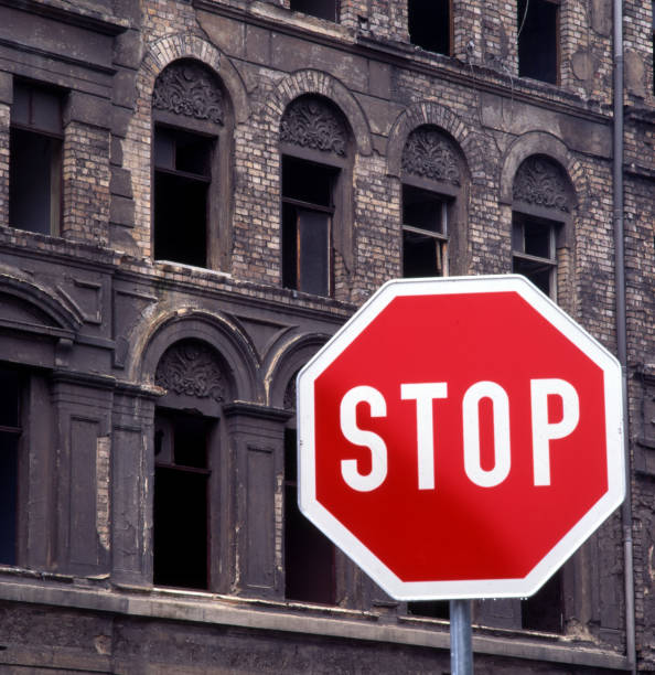 istock old ruin house with traffic sign - stop 1161609756