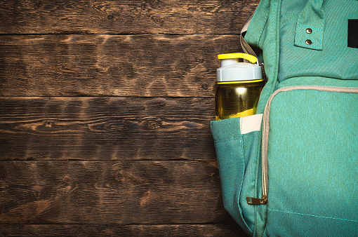 Sport flat lay background with a copy space. A backpack and yellow bottle of water.