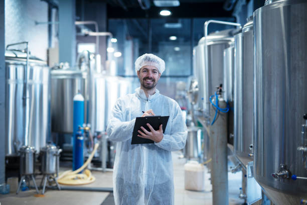 istock Food processing plant interior with positive smiling technologist holding checklist. Industrial worker satisfied with results and quality control. 1161610782