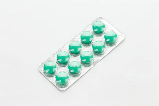 istock green pills in a blister on a white background. 1161611128