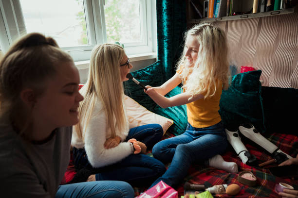 Giving Her Friend A Makeover A front-view shot of a young girl doing her friend's makeup. prosthetic equipment photos stock pictures, royalty-free photos & images