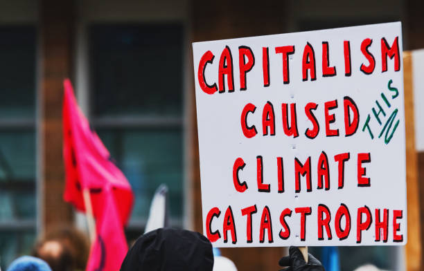 Climate Change Protest Climate change protestors hold their placards high. capitalism stock pictures, royalty-free photos & images