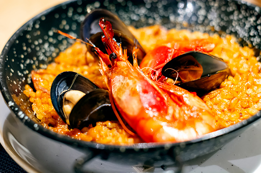 Paella with mariscos in a black pan, a typical dish of traditional Spanish cuisine based on seafood and rice. Traditional cuisine