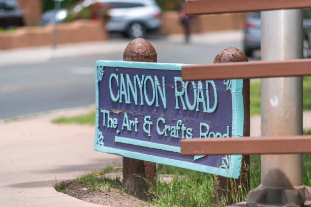 Historic downtown old town street with famous Canyon Road sign on Paseo de Peralta Santa Fe, USA - June 10, 2019: Historic downtown old town street with famous Canyon Road arts and crafts sign on Paseo de Peralta canyon road stock pictures, royalty-free photos & images