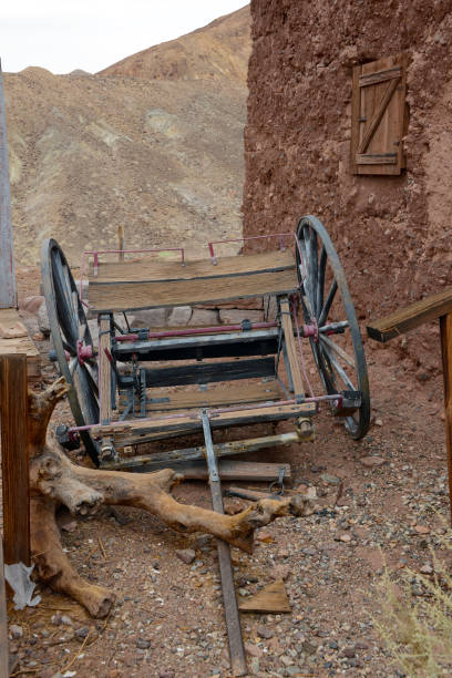 old buggy broken horse drawn buggy behind adobe building in the desert wagon wheel bench stock pictures, royalty-free photos & images