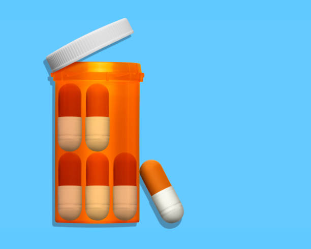 istock Large Oversized Capsules In Prescription Medication Bottles On Blue Background 1161639158