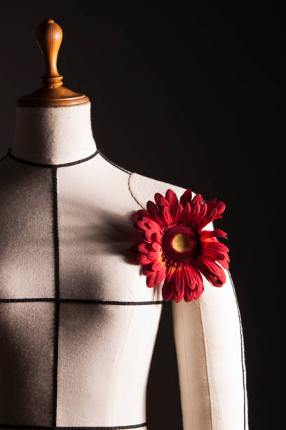 istock White manikin with red flower and black background 1161639450