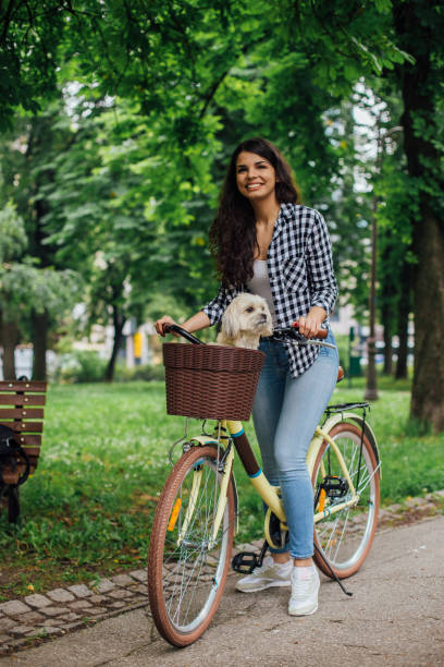 istock Happy girl riding dog on a bicycle 1161640352