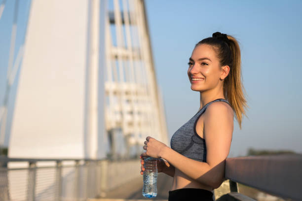 istock Smiling sports woman drinking water 1161640418