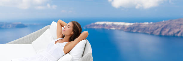 Relaxing woman sleeping enjoying outdoor sofa view Relaxing woman sleeping on outdoor daybed patio furniture enjoying view of Mediterranean sea Europe travel destination. Asian girl lying down on pillows dreaming carefree happy. Luxury home living. chaise longue woman stock pictures, royalty-free photos & images