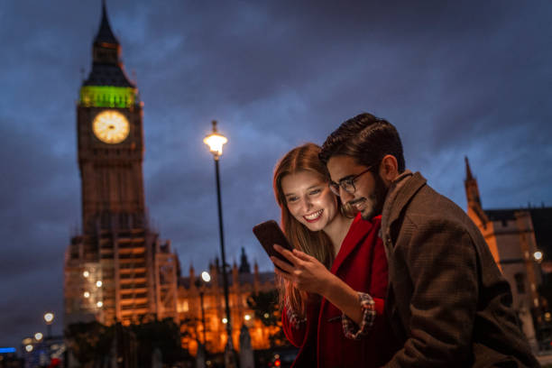 istock Young tourist using phone at night in front of Big Ben 1161641211