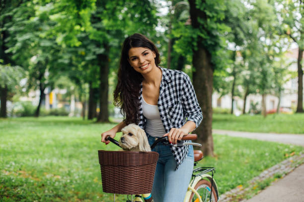 istock Girl riding dog on a bicycle and smiling 1161641300
