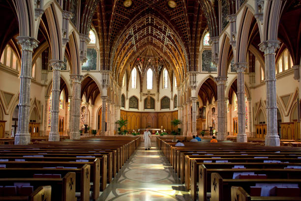 Chicago, Illinois: Horizontal view of the catholic Holy Name Cathedral interior with the priest walking along the central aisle