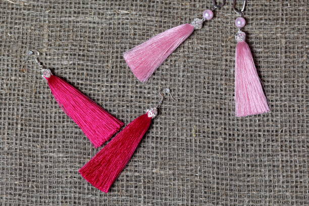istock Earrings, tassels lie on a rough linen fabric. View from above. 1161646249