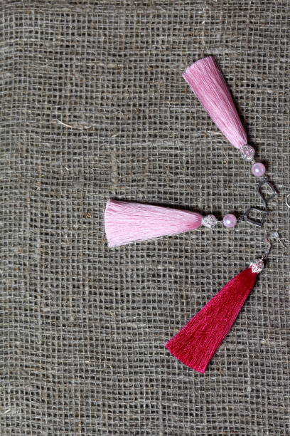 istock Earrings, tassels lie on a rough linen fabric. View from above. 1161646260