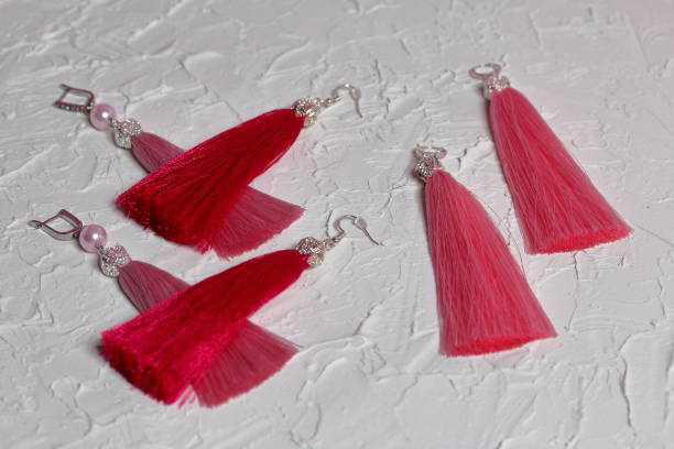 istock Earrings tassels. They lie on the surface covered with white decorative plaster. 1161646299