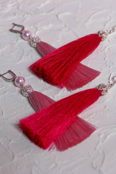 istock Earrings tassels. They lie on the surface covered with white decorative plaster. 1161646305