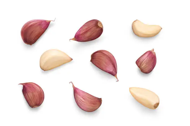 Photo of A collection of garlic cloves isolated on a white background.