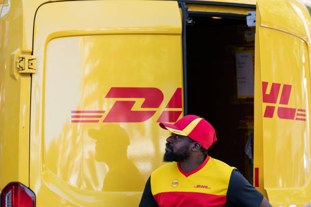 dhl delivery truck in chelsea area of city with man opening back door on street - brand name yellow red business imagens e fotografias de stock