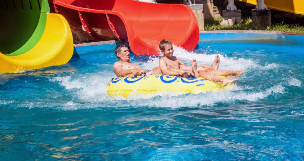 glückliche zweierfamilie nach wasserparkrutsche - amusement park family water slide child stock-fotos und bilder