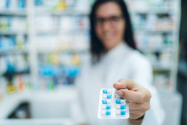 istock Female pharmacist offering medicine in blister pack 1161651222