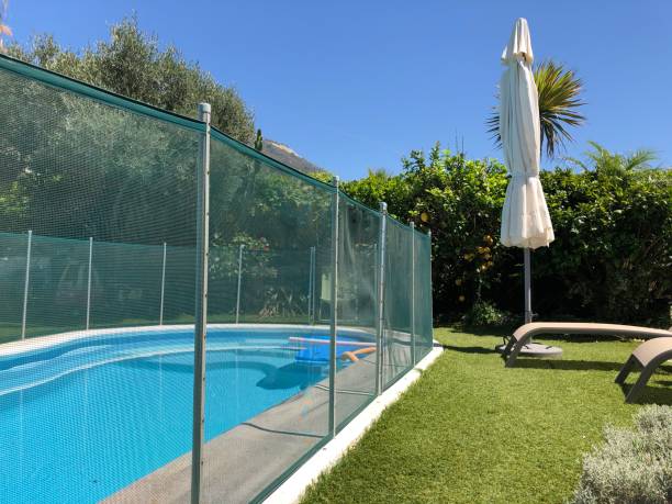 Swimming pool with safety fence Home swimming pool in garden with safety fence gibraltar photos stock pictures, royalty-free photos & images