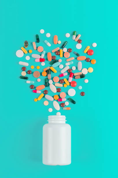 istock Assorted pharmaceutical medicine pills, tablets and capsules and bottle on blue background. Copy space for text 1161653326